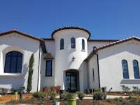 the exterior of a white house with a red roof